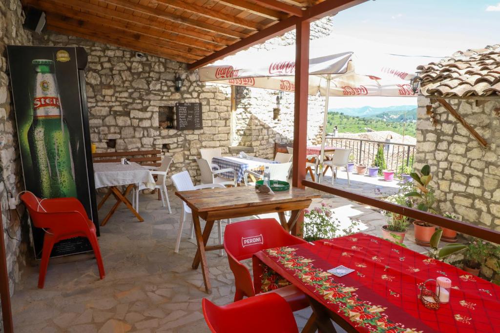 a patio with a table and chairs and an umbrella at Guest House Vasili in Berat