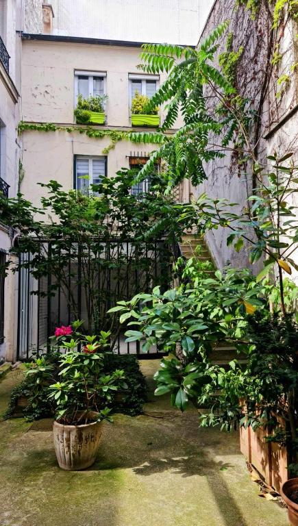 une maison avec des plantes devant une clôture dans l'établissement Petit cocon parisien ! Paris Centre - Gare du Nord, à Paris