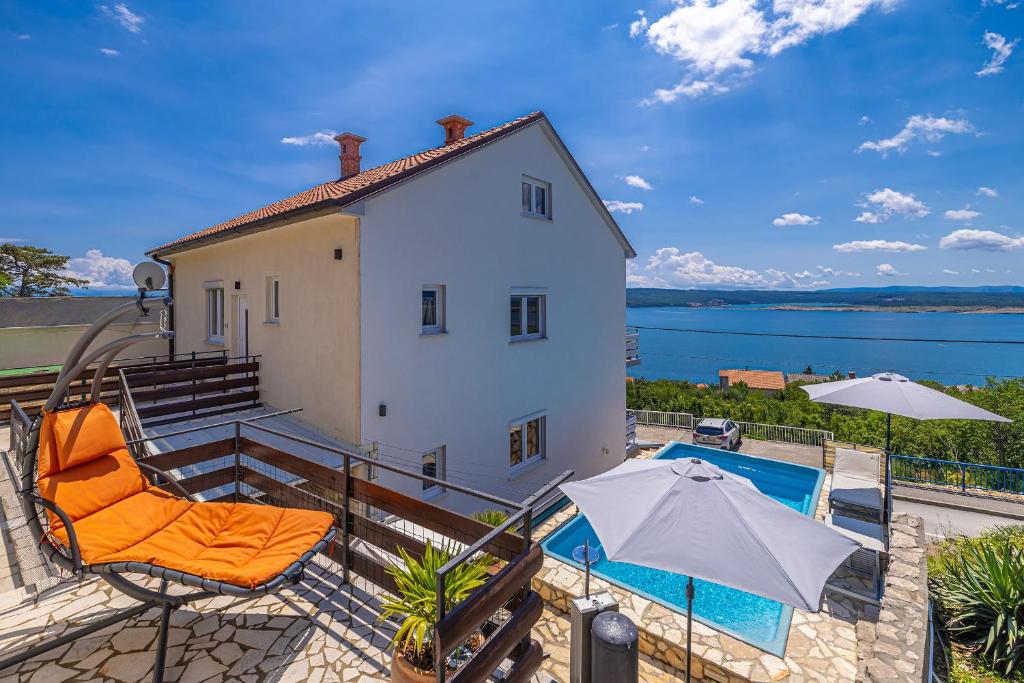 a house with a pool and two chairs and an umbrella at Hot Tub, Pool & Stunning View #Guest House Stella# in Dramalj