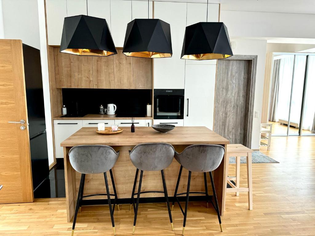 a kitchen with a wooden table with four chairs at Spacious Family Apartment by the Sea in Jūrmala