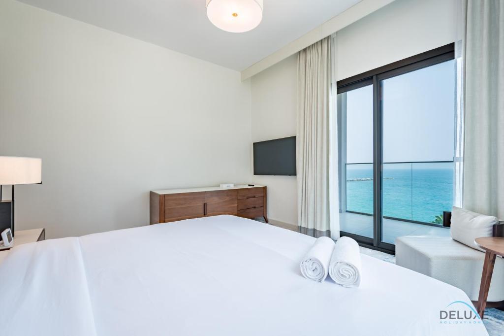 Postel nebo postele na pokoji v ubytování Seafront 4BR Apartment with Assistant Room in The Address Fujairah Residences Block B, Fujairah by Deluxe Holiday Homes