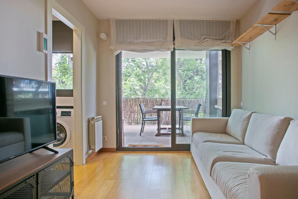 a living room with a couch and a television at Winahost La Terraza de Sant Cugat in Sant Cugat del Vallès