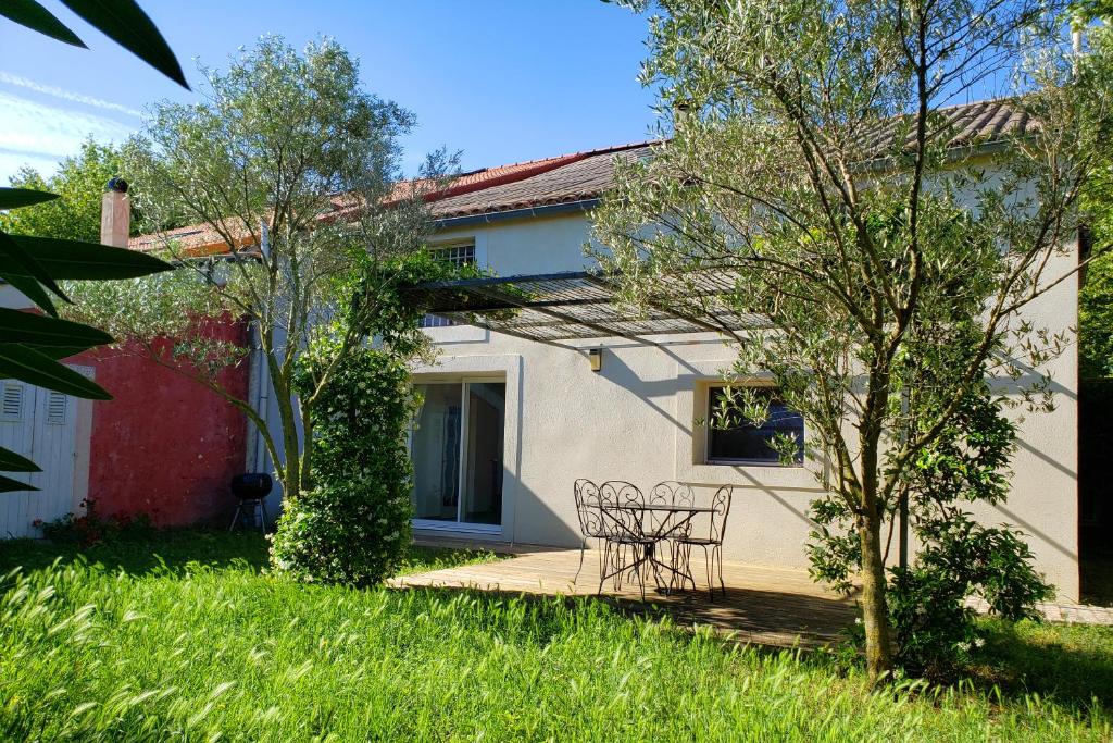 a house with a table and chairs in the yard at Les Airis in Avignon