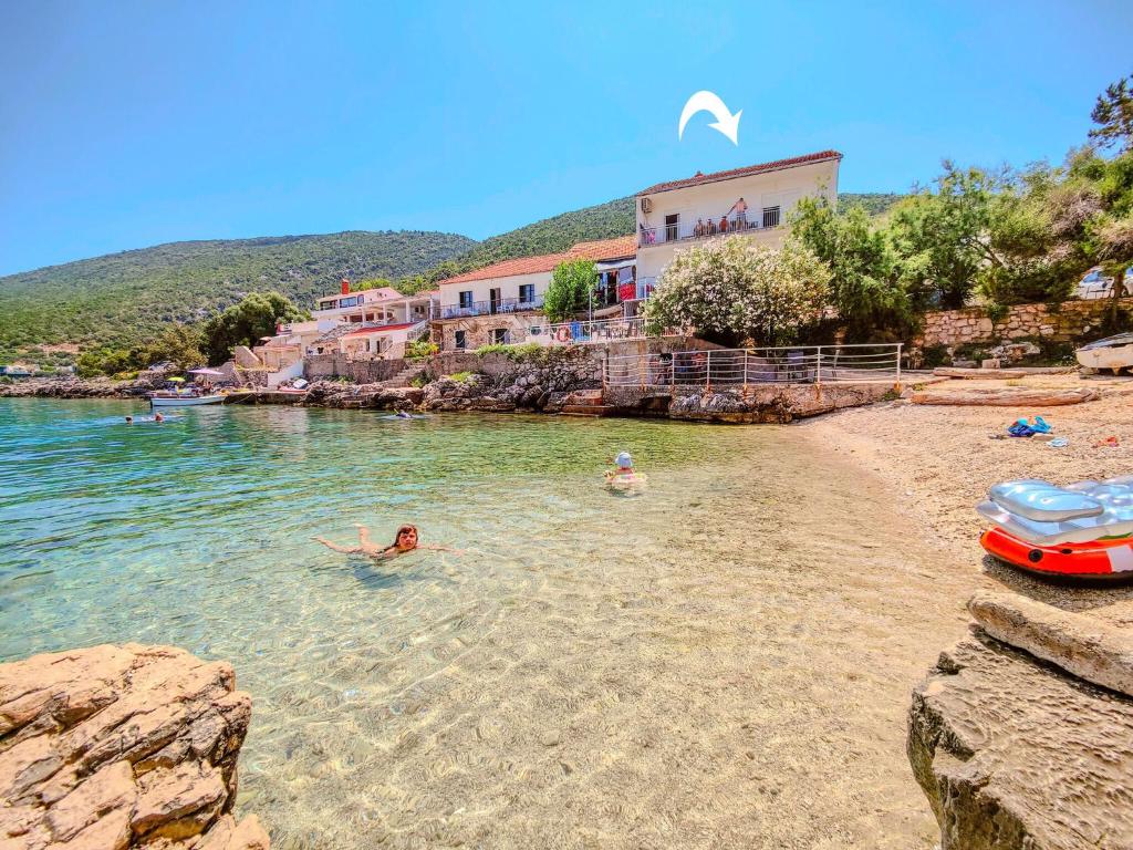 two people swimming in the water on a beach at Apartmány Viktor in Selca kod Bogomolja