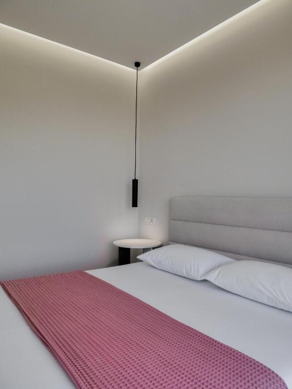 a bedroom with a white bed with a pink blanket at Villa Tonia in Himare