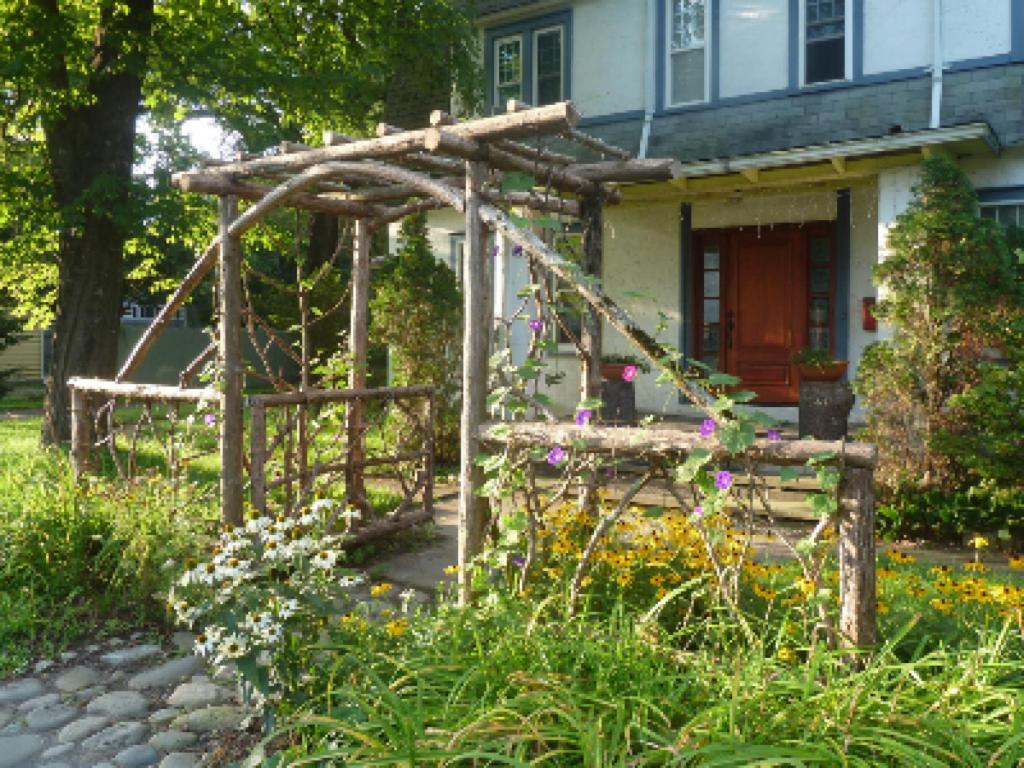 a house with a wooden pergola in front of it at Morning Glory B&B in Woodstock