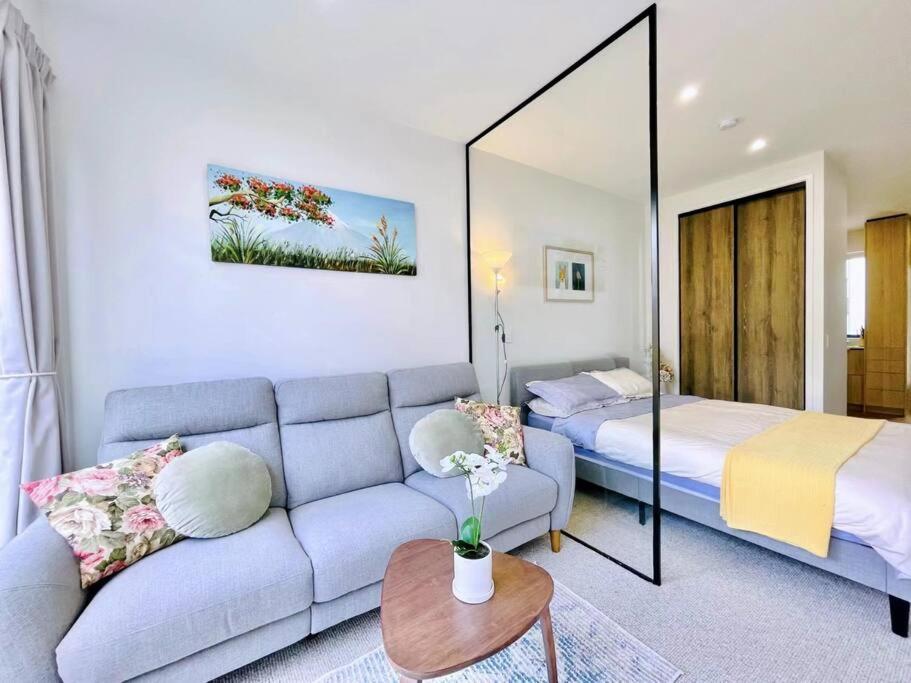 a living room with a couch and a bed at New townhouse with garden in the city centre in Auckland