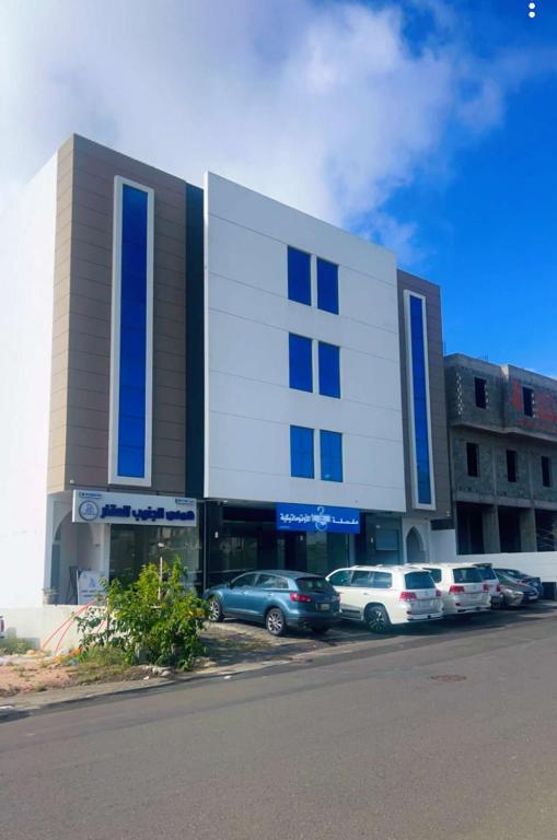 a building with cars parked in a parking lot at السكن المثالي - alsakan almithaliu in Abha