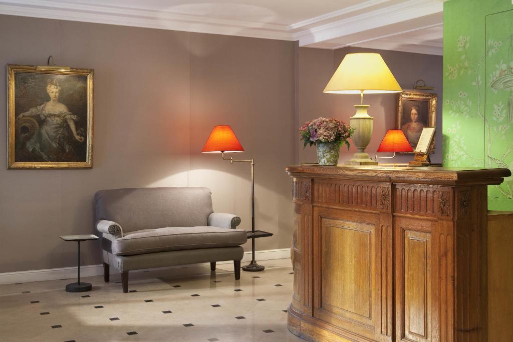 a living room with a chair and a lamp at Hôtel du Danube Saint Germain in Paris