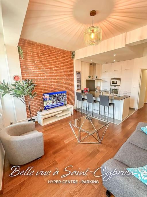 Il dispose d'une cuisine et d'un salon avec un mur en briques. dans l'établissement Belle vue à Saint-Cyprien-Parking-Hyper Centre, à Toulouse
