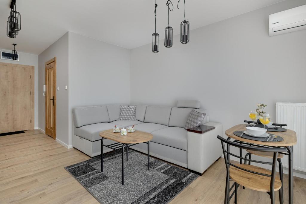 a living room with a couch and a table at Eleganckie Studio Basen, Fitness & Balkon by Noclegi Renters in Dziwnów