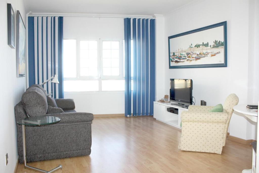 ラスパルマス・デ・グランカナリアにあるLPA Stop Apartmentのリビングルーム(ソファ、椅子、テレビ付)