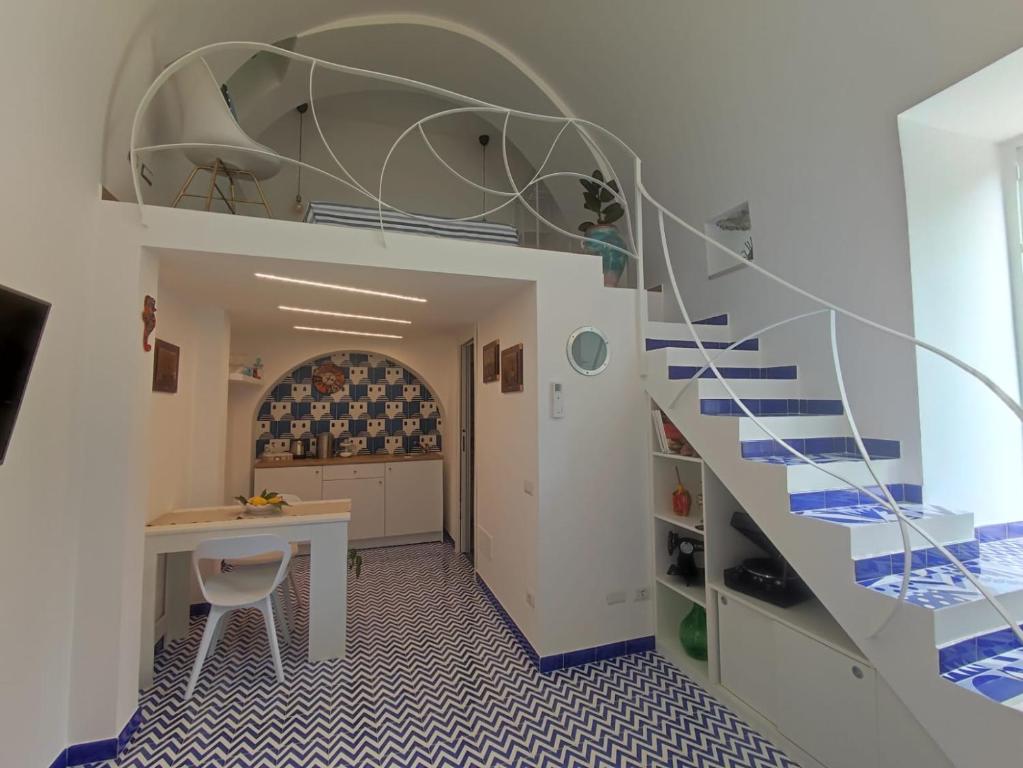 a spiral staircase in a room with a table and a desk at Villa Nina La torretta in Pontone