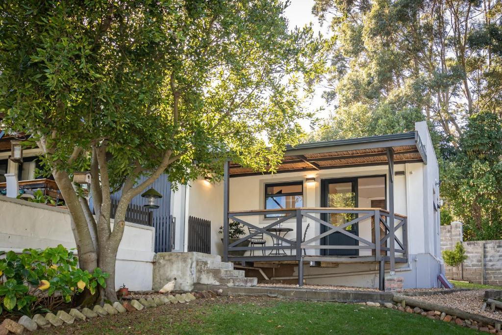 a small house with a porch and a tree at Novelle Vista Cottage in Hout Bay
