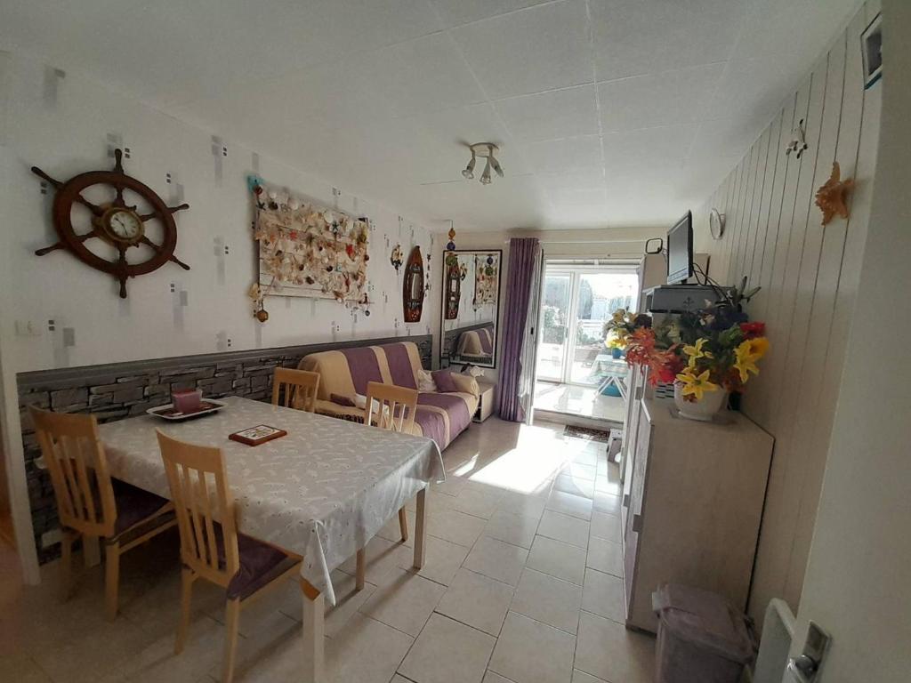 un salon avec une table, des chaises et un canapé dans l'établissement Appartement RDC avec Véranda et Terrasse, Proche Plage et Commerces, Parking Privatif - FR-1-324A-50, à Saint-Hilaire-de-Riez