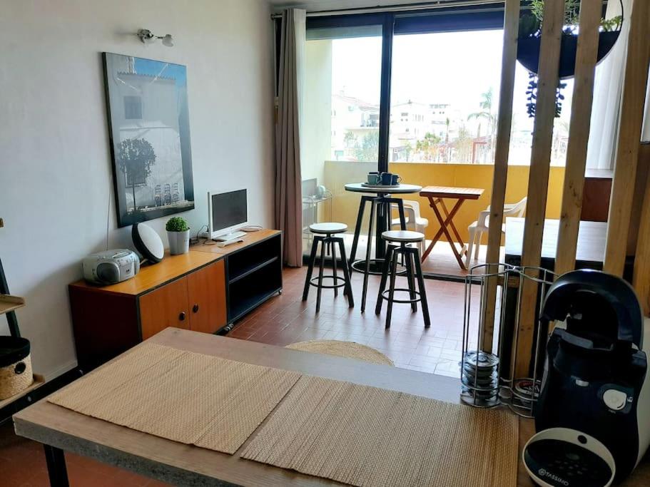 un salon avec une table et quelques chaises dans l'établissement T3 centre Narbonne-plage vue Mer, à Narbonne-Plage