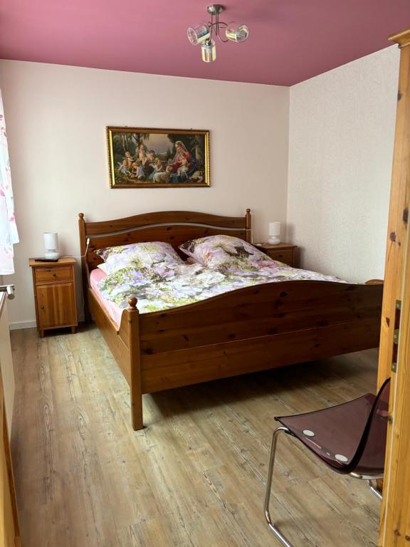 una camera con letto in legno e un dipinto sul muro di Altes Zollhaus a Fehmarn