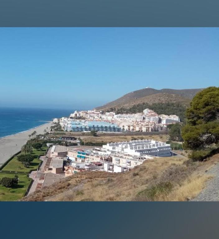 a group of houses on a hill next to the ocean at Casa Angeles in Castell de Ferro