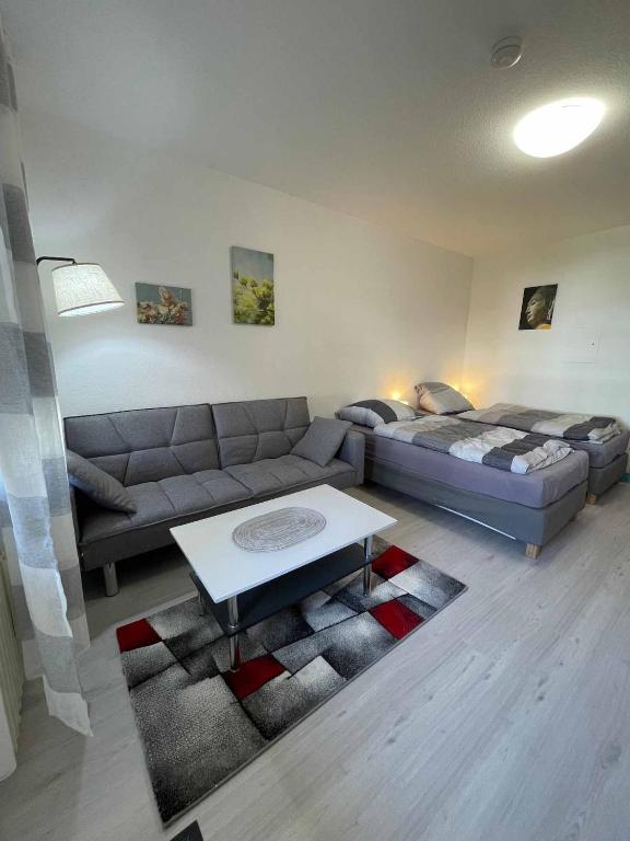 a living room with a couch and a table at Appartement am Brunnenplatzl mit Bademantelzugang in Bad Griesbach