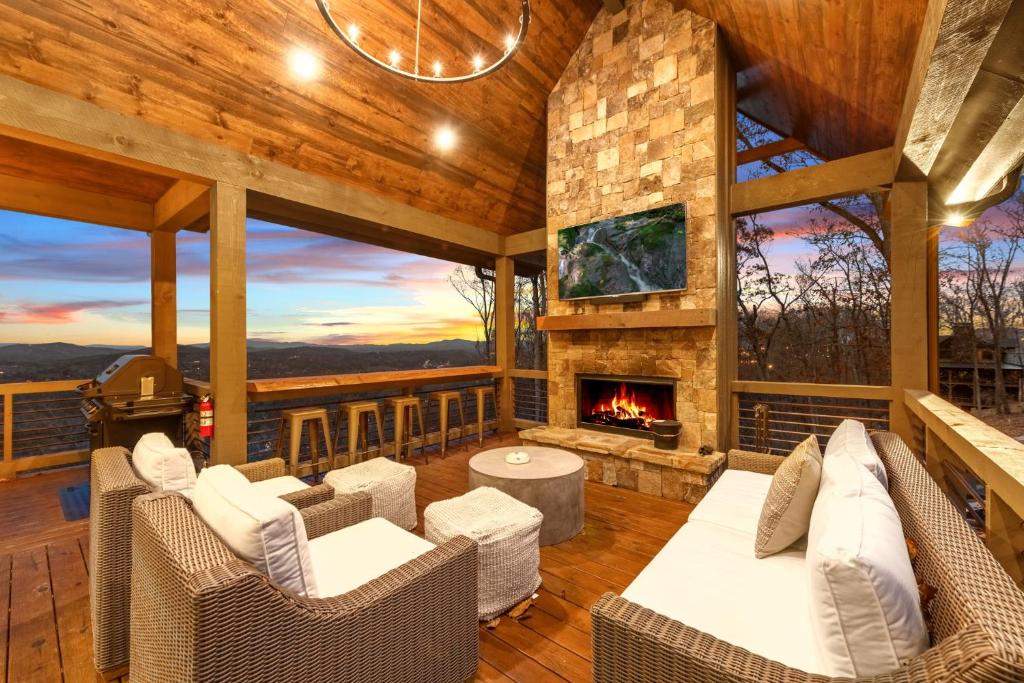 ein Wohnzimmer im Freien mit Kamin und Korbmöbeln in der Unterkunft Blue Run Cabin - Luxury Retreat Blue Ridge Heights - Hot Tub, Movie Theater, Game Room, Fire Pit, Mountain Views - Blue Ridge, G in Blue Ridge