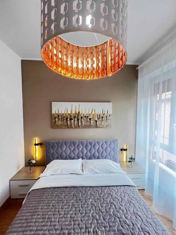 a bedroom with a bed and a large chandelier at BolognaBySide -RIGHI in Bologna