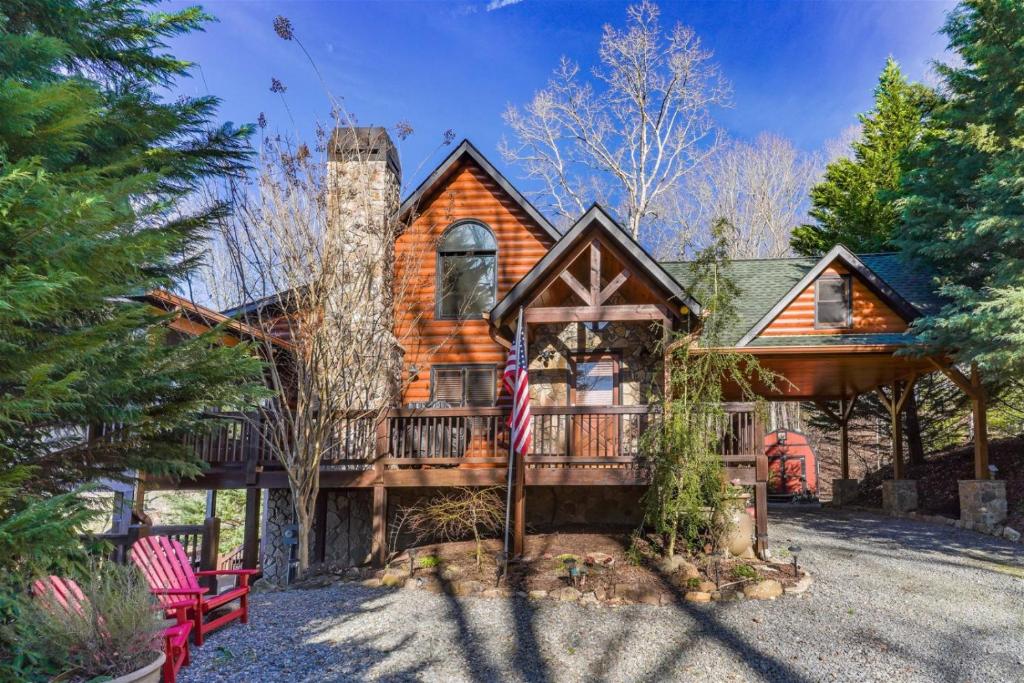 a log home with a porch and a flag at Mountain Melody in Morganton