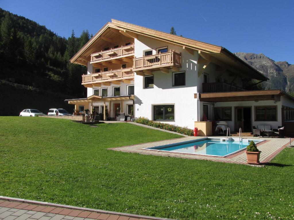 a house with a swimming pool in front of it at Pension Waldesruh in Sölden