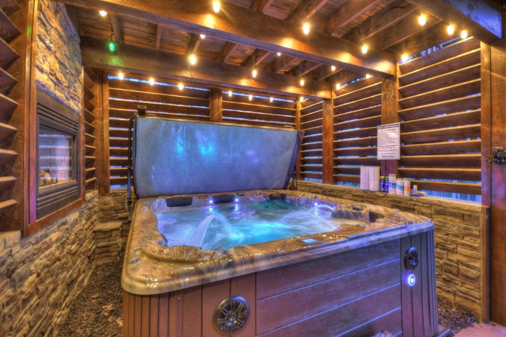 a jacuzzi tub in a wooden room with lights at Sassafras Lodge - Cabin in North GA - Pet Friendly - Hot Tub, Fireplace, Mountain Views, Gas Griddle, Outdoor Fire Pit, Shuffleb in Mineral Bluff