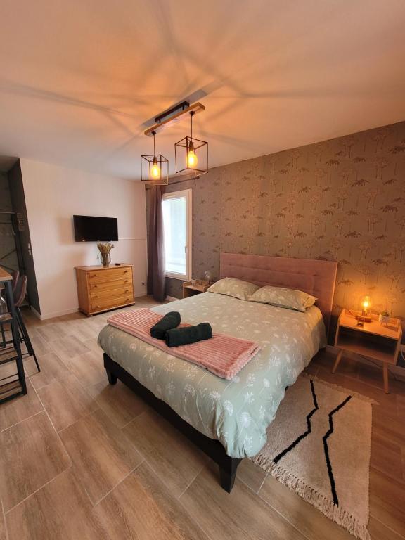 - une chambre avec un grand lit et une télévision dans l'établissement L' Écrin de Jade, à Melun