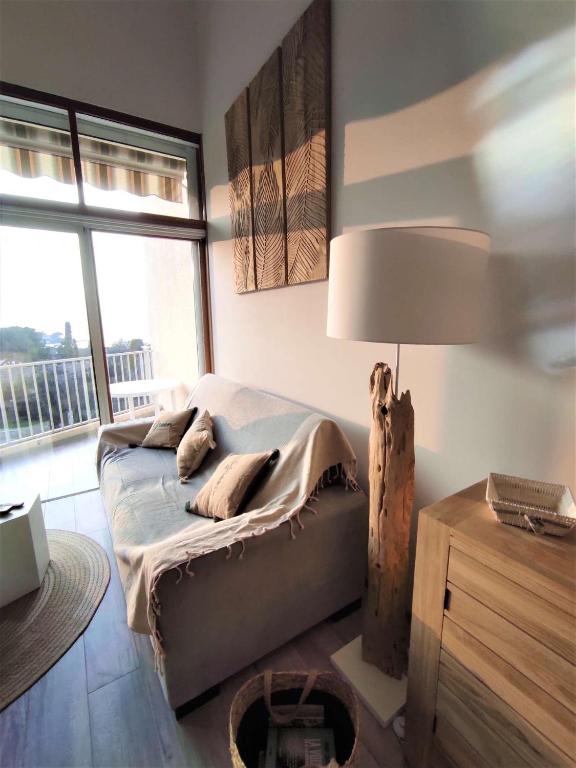 une chambre avec un lit avec une lampe et une fenêtre dans l'établissement Appartement 2 pièces duplex Hotel Club Porticcio, à Porticcio