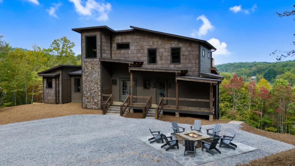 a house with a table and chairs in front of it at Vacay Chalet - Luxury Cabin in North Georgia - Floor-To-Ceiling Stone Fireplace, Professionally Decorated, Designer Furnishings, in Blue Ridge