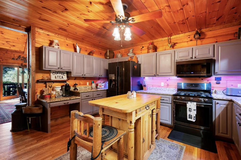 a kitchen with white cabinets and a wooden ceiling at Hazy Hideaway with View of Ellijay River in the North GA Mountains in Cherry Log