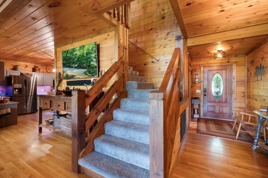 a staircase in a log cabin with a kitchen and dining room at Hazy Hideaway with View of Ellijay River in the North GA Mountains in Cherry Log