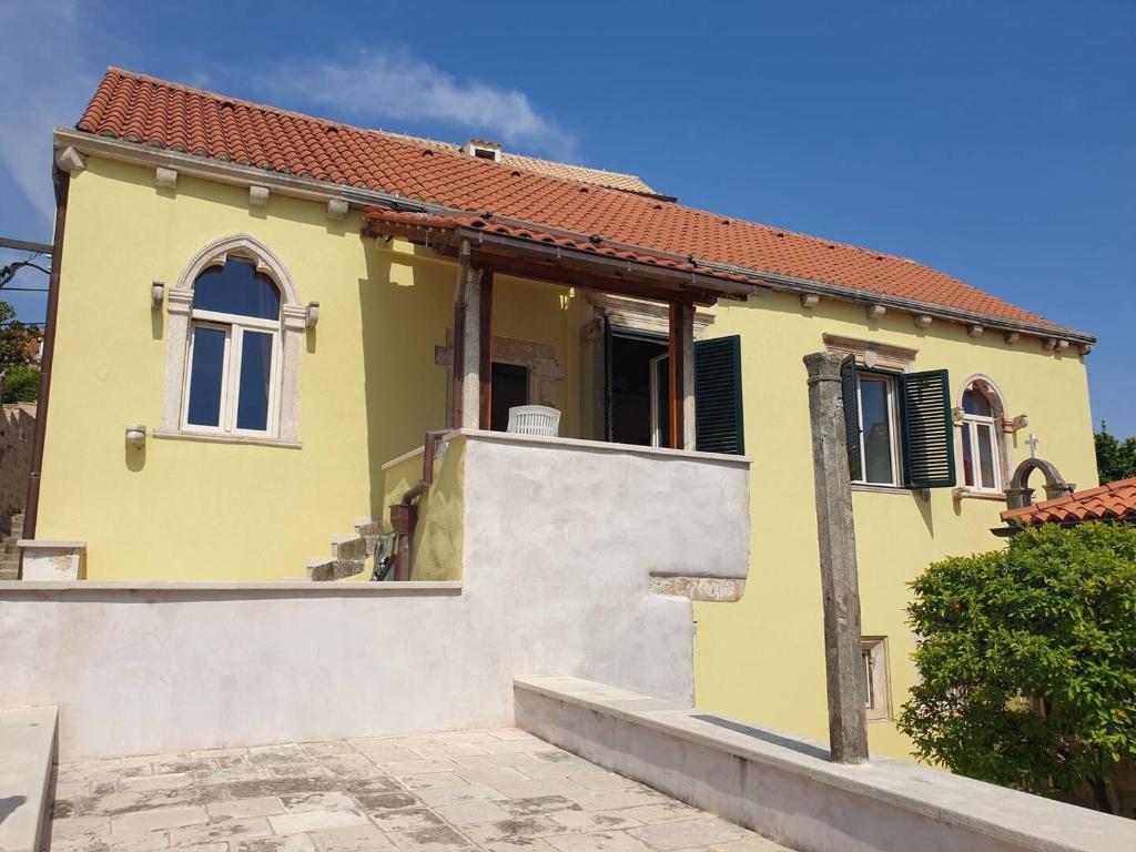 a yellow house with a tile roof at Palace Pernarius in Cavtat
