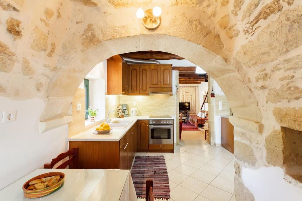 kuchnia z kamienną ścianą i łukiem w obiekcie Tzitzifes Stone Mansion w mieście Tzitzifés