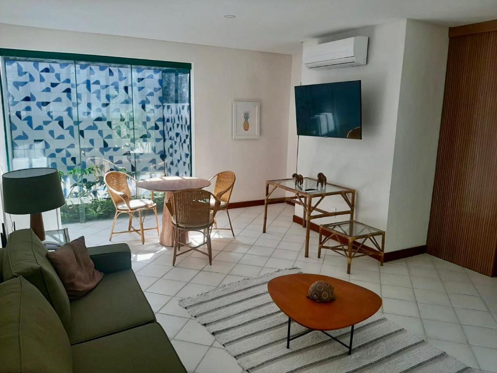 Hotel 7 Colinas في أوليندا: غرفة معيشة مع أريكة وطاولة