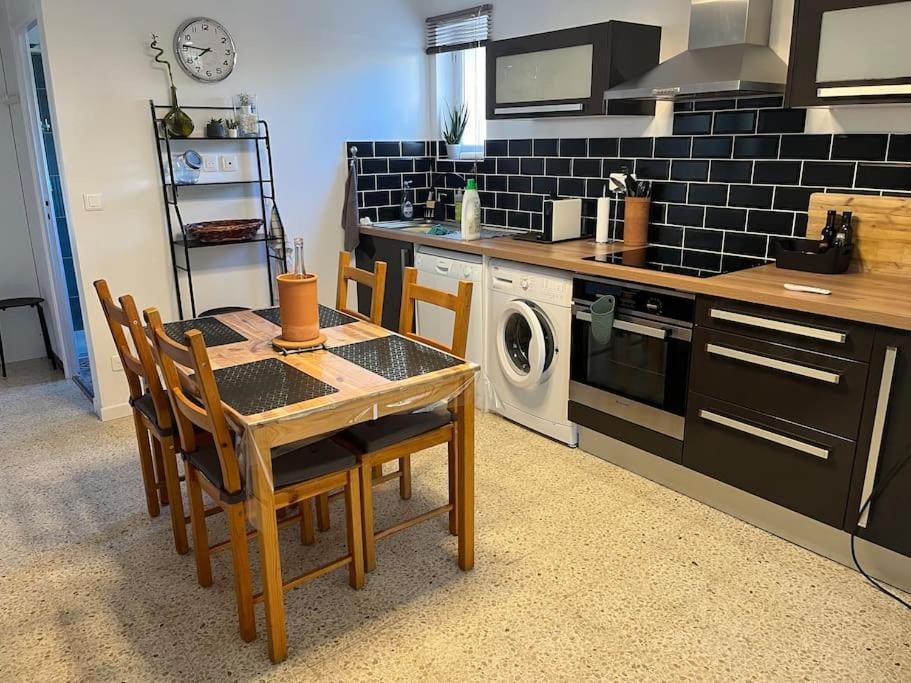 une cuisine avec une table et des chaises dans une cuisine dans l'établissement New Appartement RDC de Villa 60 m2 proche plage, à La Ciotat
