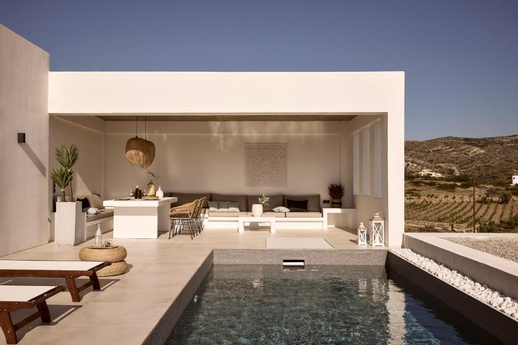a house with a swimming pool and a living room at Thea Luxury Villas Ios in Ios Chora
