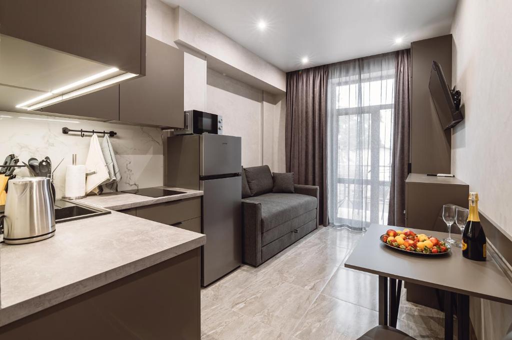 a kitchen with a couch and a table with a bowl of fruit at Club Marine Apart in Odesa