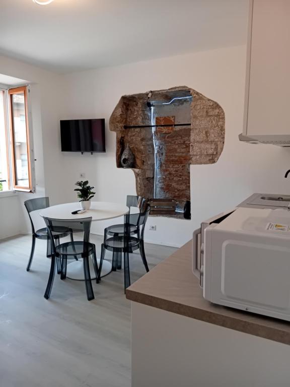 a kitchen with a table and chairs and a microwave at Piazza Roma apartment next como lake and station by revenue house in Como