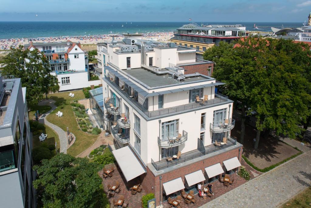 eine Luftansicht eines Gebäudes mit Meerblick im Hintergrund in der Unterkunft Park-Hotel Hübner in Warnemünde