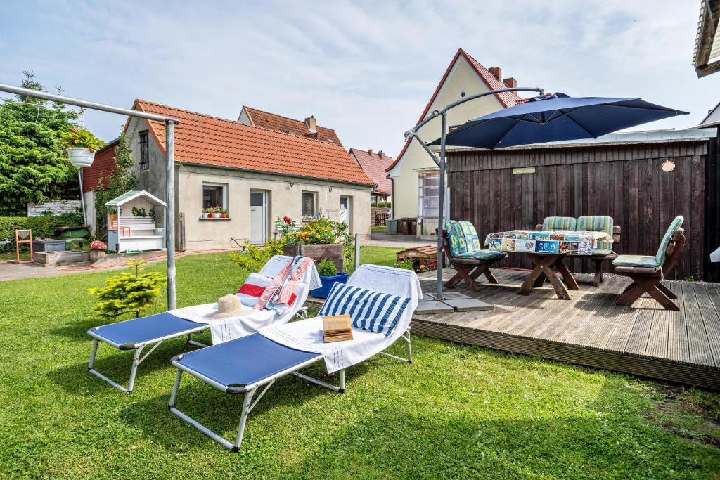 a patio with a table and chairs and an umbrella at Ferienwohnung auf der Insel Rügen in Bergen auf Rügen