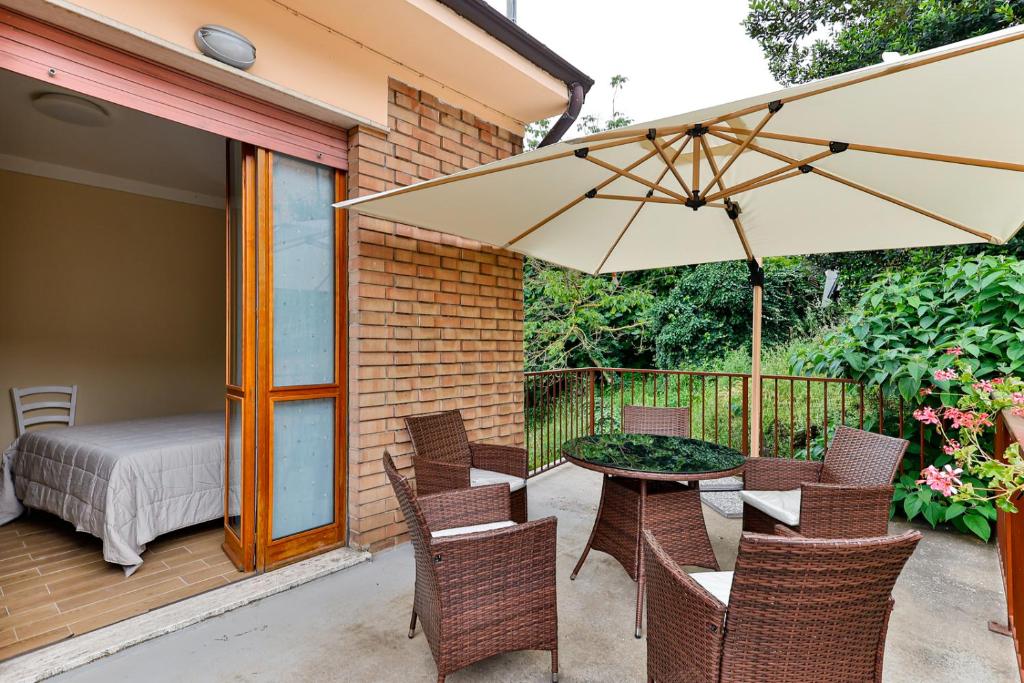 a patio with a table and chairs and an umbrella at Il Borghetto di Castagnole in Castagnole Monferrato