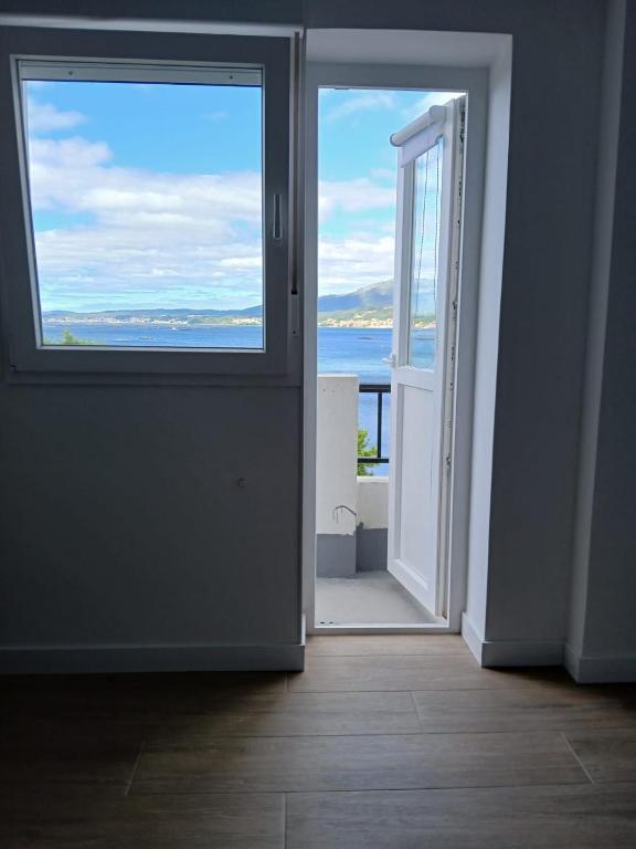 an open door with a view of the ocean at Hostal Terraza Miramar SL in Boiro