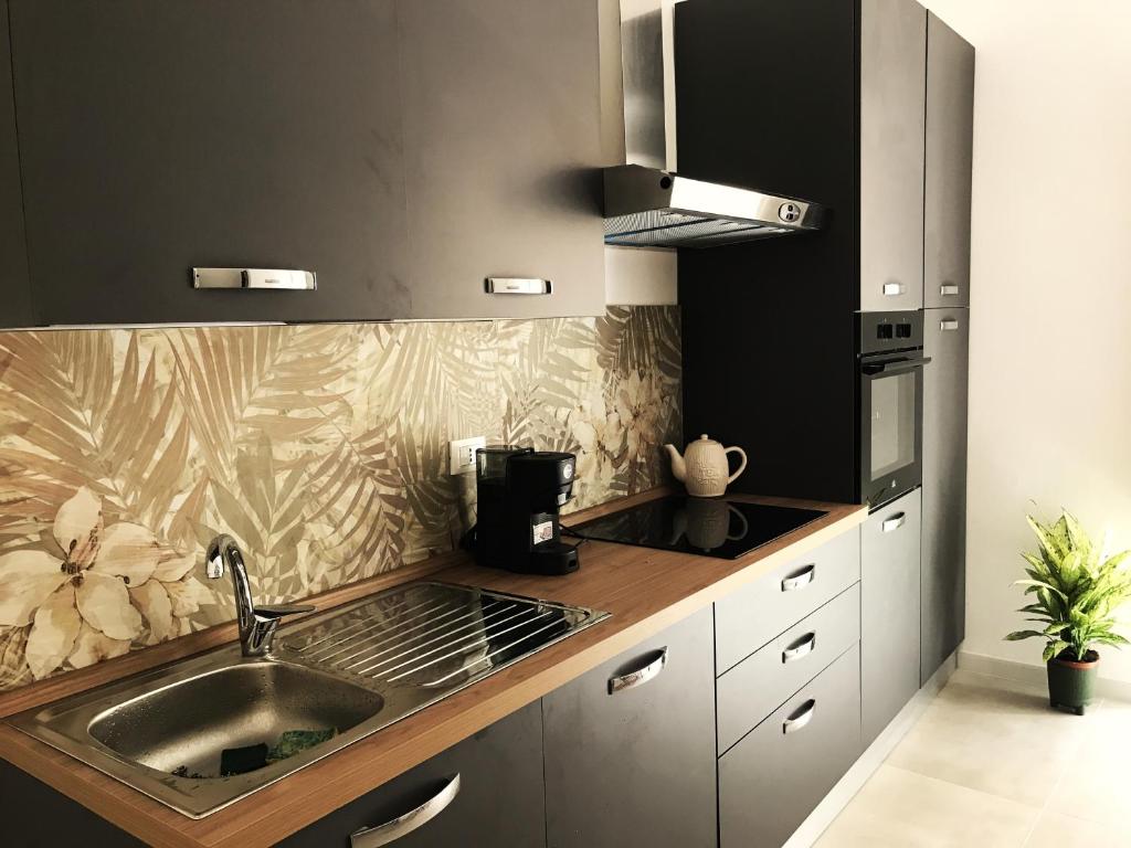 una cocina con fregadero y estufa en Palermo Maison, en Palermo