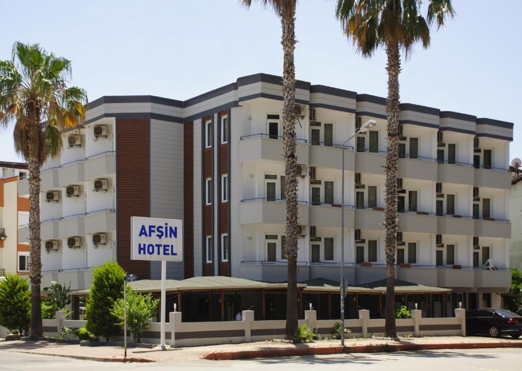 an asian hotel with palm trees in front of it at Afsin Hotel in Antalya