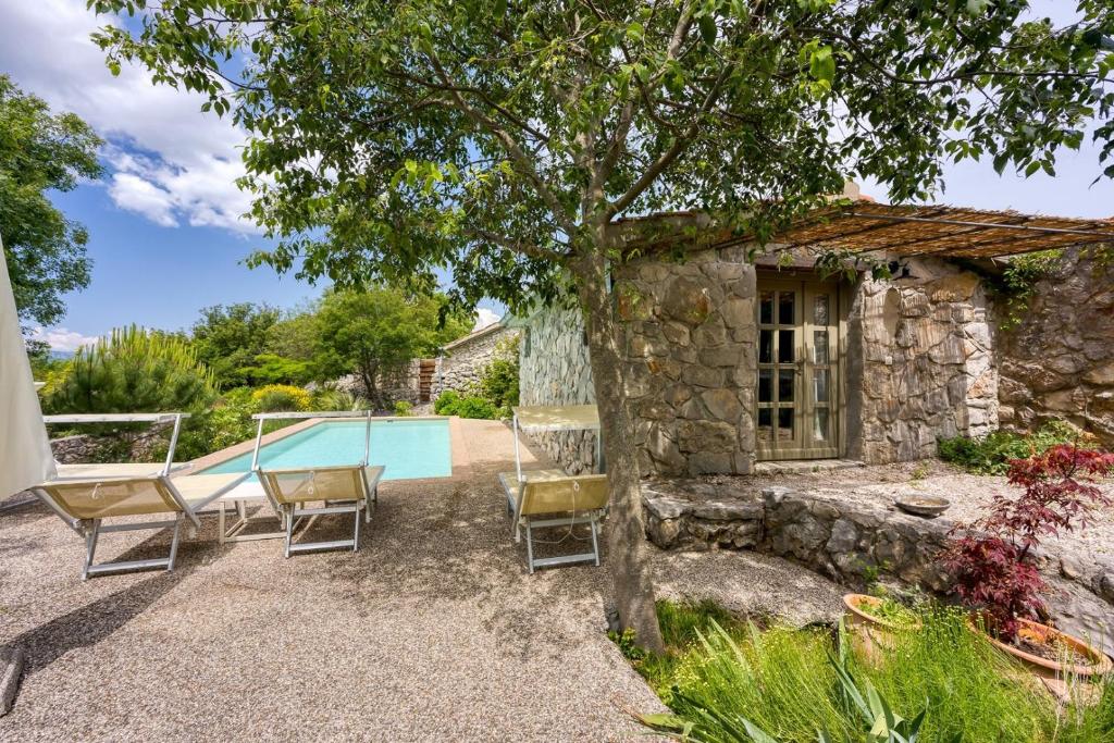 a patio with chairs and a swimming pool at Villa Menta 2 2445 in Malinska