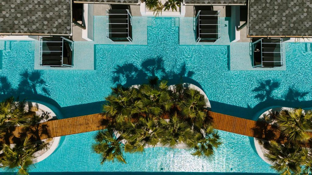 an overhead view of a swimming pool with palm trees at Kallithea Village hotel in Kallithea Halkidikis