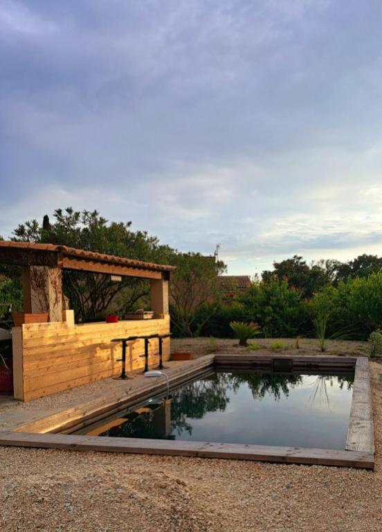 un bassin d'eau dans un jardin avec un pavillon dans l'établissement maison familiale, à Villevieille