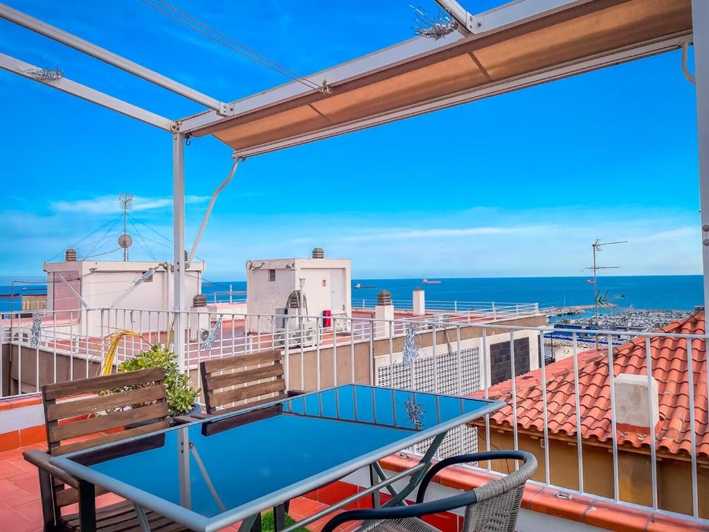 a table and chairs on a balcony with the ocean at Attic by Unik Vacation in Tarragona